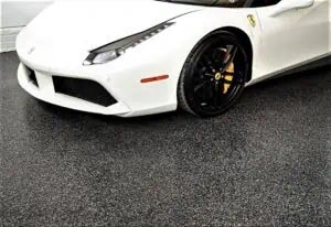 White sports cars parked on a black speckled garage floor coating