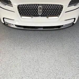 Gray full flake epoxy and polyaspartic coating with a white Lincoln parked on it.
