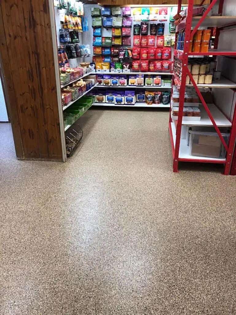 Shelving in a storage space sits atop a stunning full flake epoxy floor.